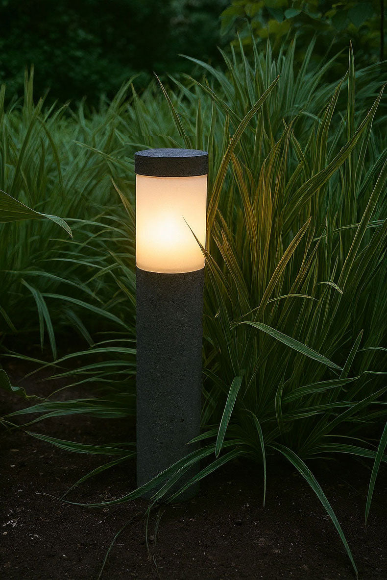 Garden light post illuminating grass in a dark setting