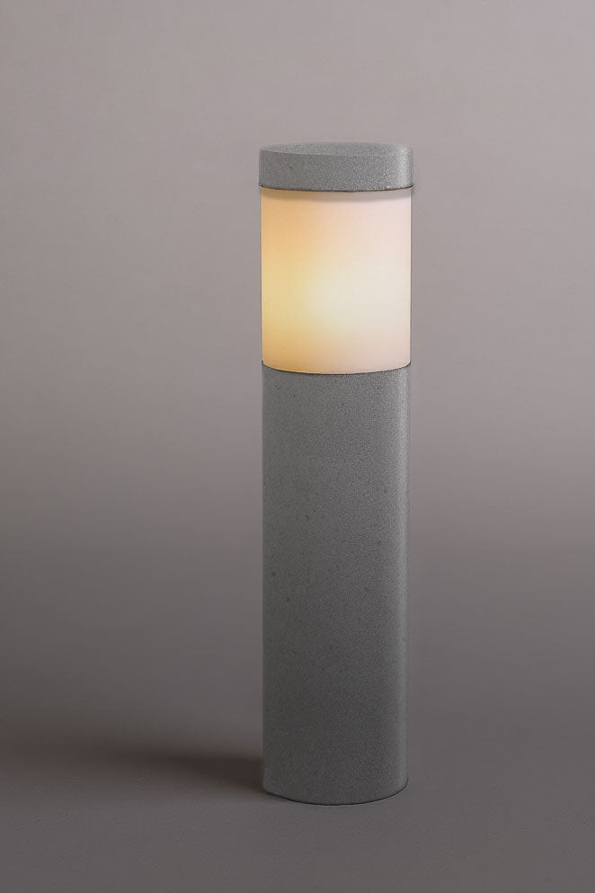 Cylindrical concrete lamp with a glowing interior on a gray background