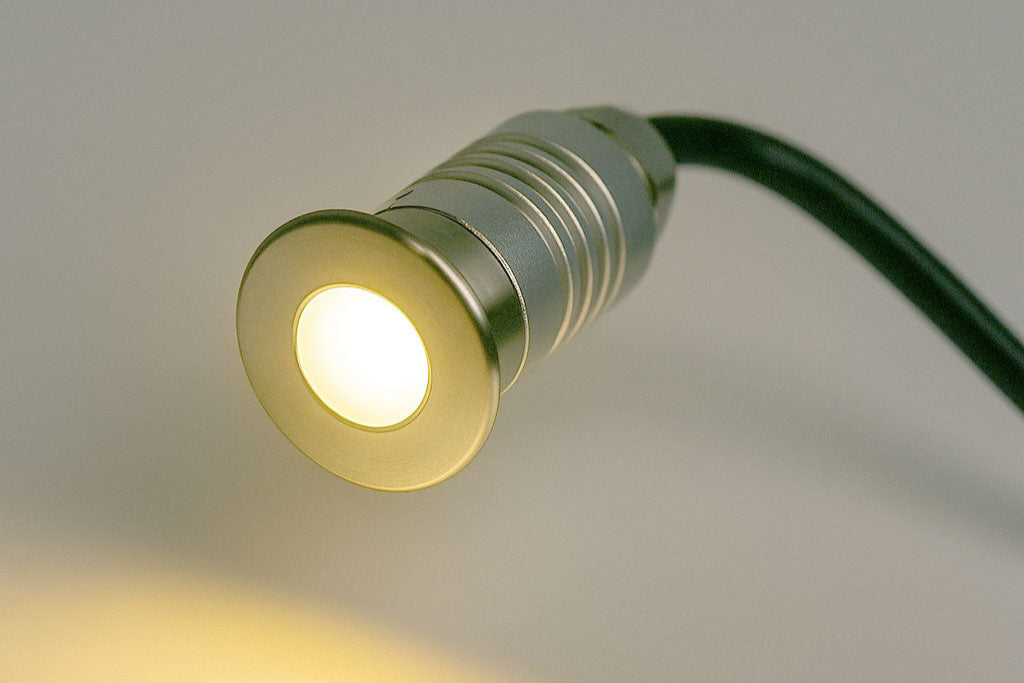 Small LED light bulb with a visible cord on a neutral background
