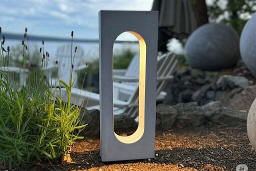 Modern outdoor concrete light with a geometric design in a garden setting.