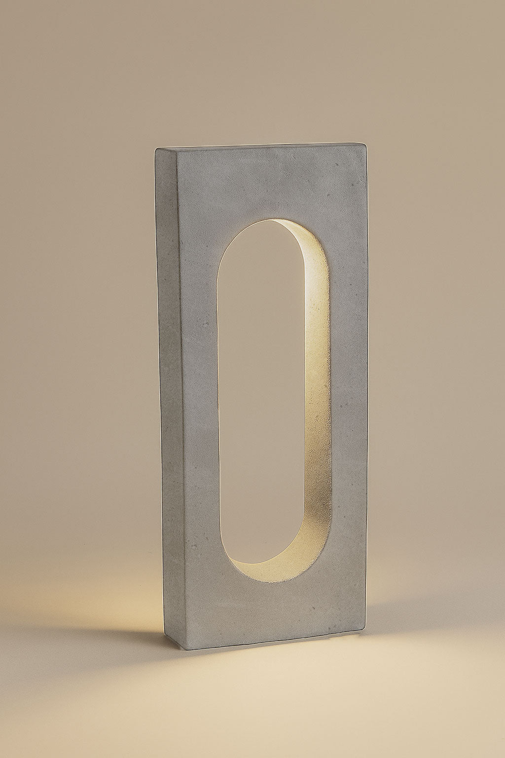 Rectangular concrete block with an oval cutout on a beige background