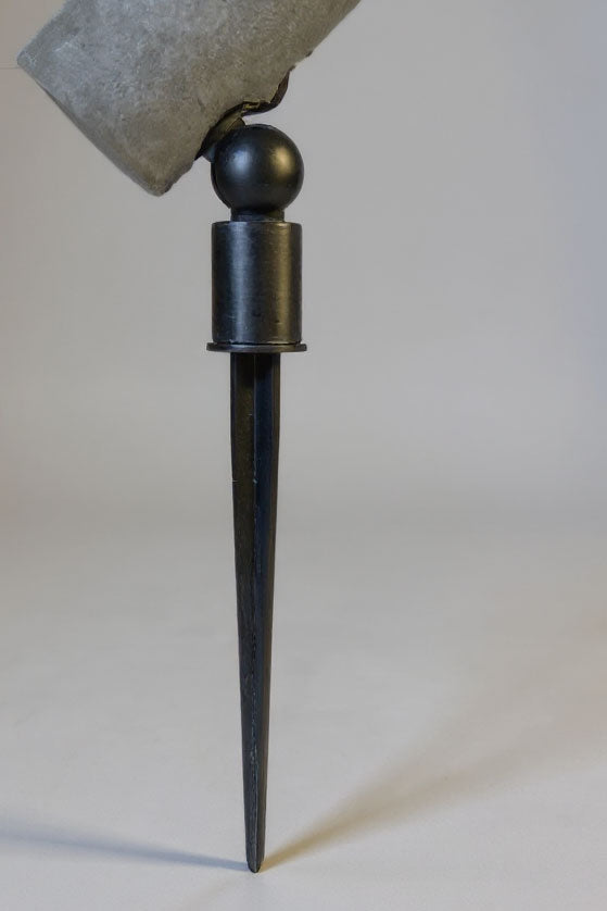 metal stake with a ball top on a plain background